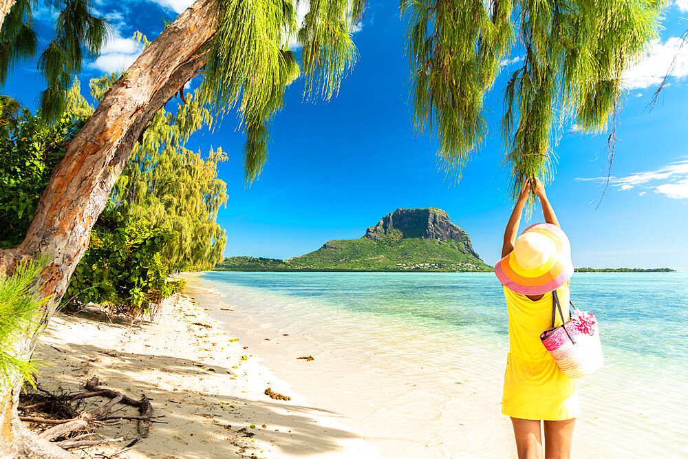 Woman having fun under a tropical tree on sandy beach, Ile aux Benitiers, La Gaulette, Le Morne Brabant, Mauritius, Indian Ocean, Africa