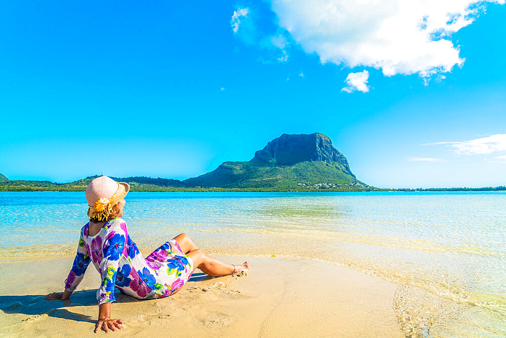 Woman in bright dress relaxing on tropical beach, La Gaulette, Le Morne Brabant, Mauritius, Indian Ocean, Africa