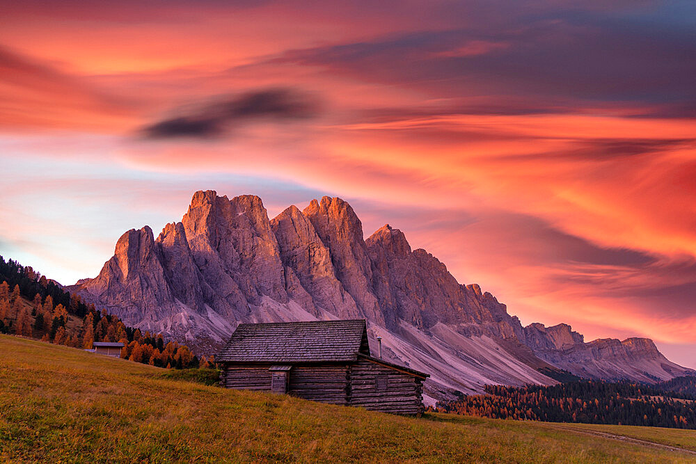 Sunrise over the Odle peaks and traditional hut in Gampen Alm in autumn, Funes Valley, Dolomites, Bolzano, South Tyrol, Italy, Europe