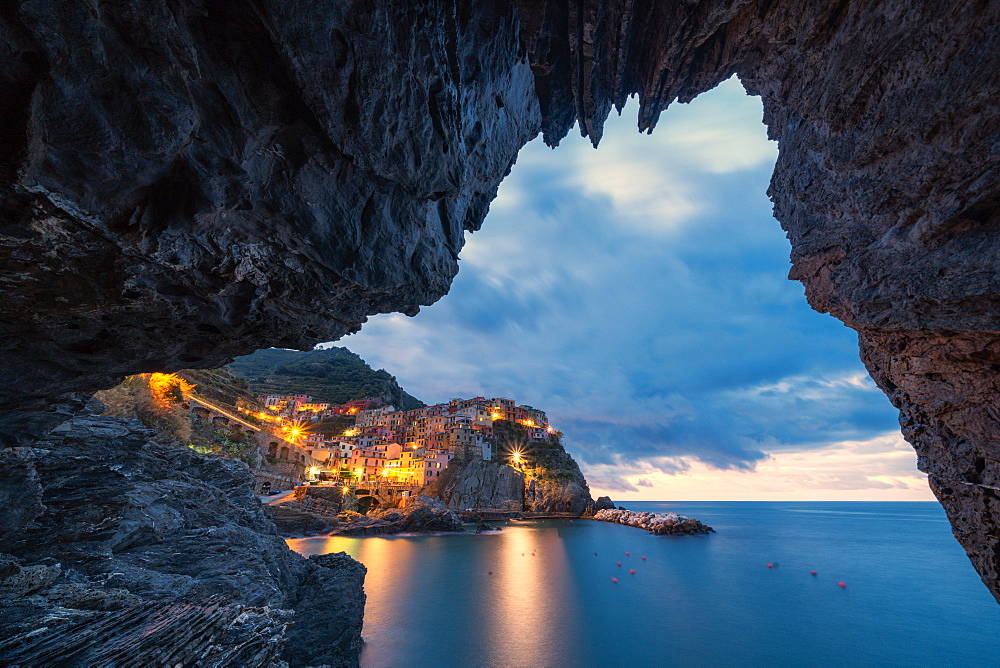 Manarola at dusk view from a grotto, Cinque Terre, UNESCO World Heritage Site, La Spezia province, Liguria, Italy, Europe