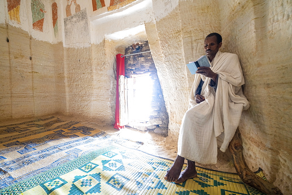 Priest holding the prayer book in the Orthodox Christian Daniel Korkor church, Gheralta Mountains, Tigray Region, Ethiopia, Africa