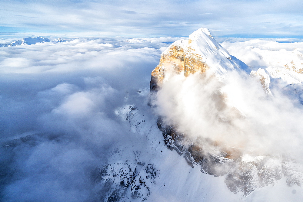 Snow covered Tofana di Rozes above the clouds, aerial view, Dolomites, Belluno province, Veneto, Italy, Europe