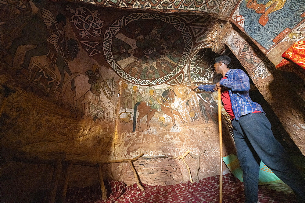 Local guide showing fresco and paintings inside Abuna Yemata Guh church, Gheralta Mountains, Tigray Region, Ethiopia, Africa