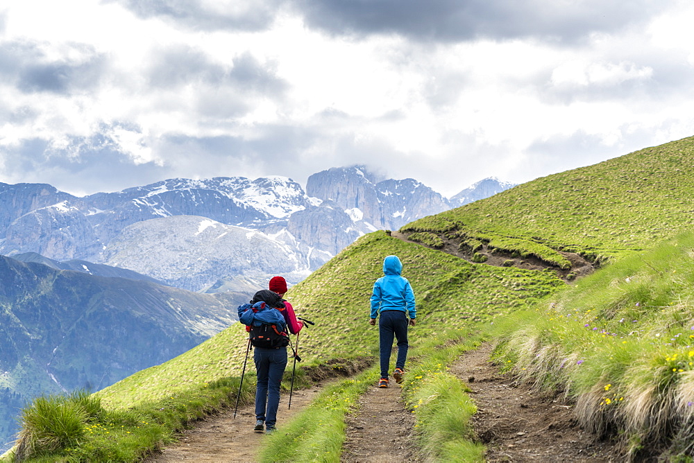 Rear view of mother with male child trekking around the Sassolungo group, Dolomites, Trentino-Alto Adige, Italy, Europe