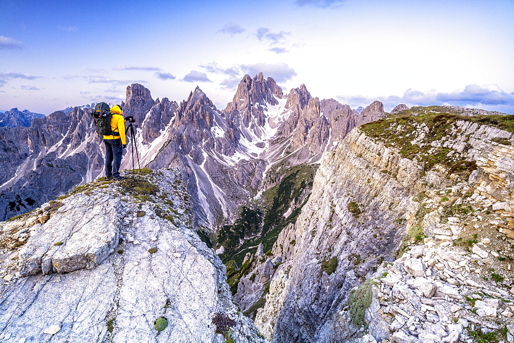 Man on top of rocks photographing Cadini di Misurina at sunrise, Dolomites, Belluno province, Veneto, Italy, Europe