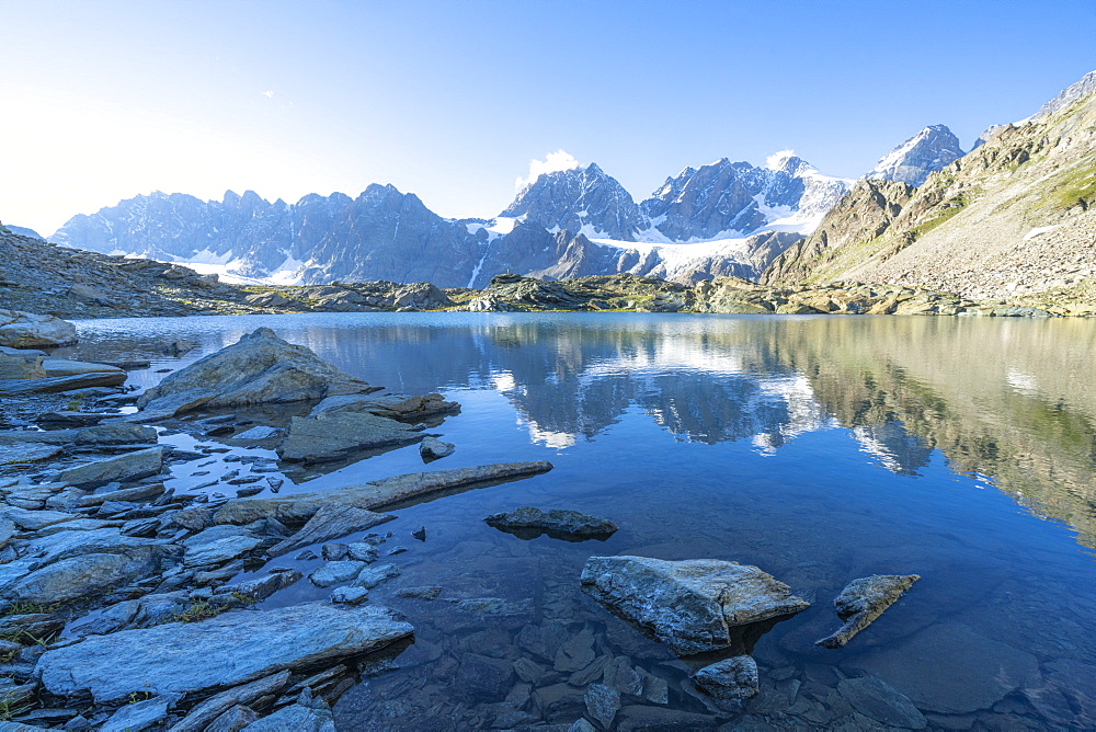 Bernina Group reflected in the clear water of Forbici lake at dawn, Valmalenco, Valtellina, Sondrio province, Lombardy, Italy, Europe