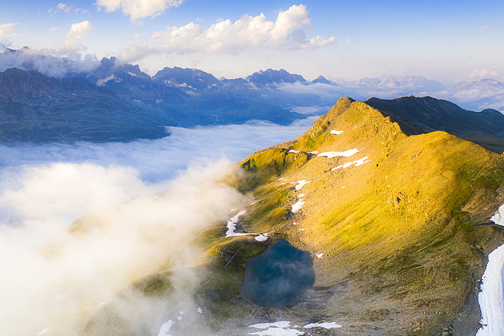 Schwarziseeli lake and Stotzigen Firsten mountain emerging from a sea of clouds, aerial view, Furka Pass, Canton Uri, Switzerland, Europe