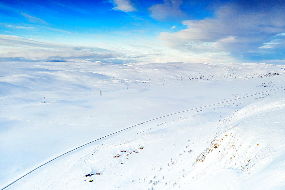 Aerial view of empty road crossing mountains covered with deep snow after blizzard, Sennalandet, Alta, Troms og Finnmark, Arctic, Norway, Scandinavia, Europe