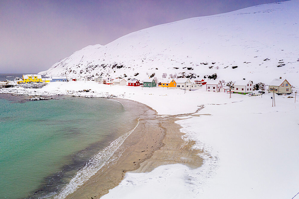 Cold sea surrounding Sorvaer village and sand beach covered with snow, Soroya Island, Hasvik, Troms og Finnmark, Arctic, Norway, Scandinavia, Europe