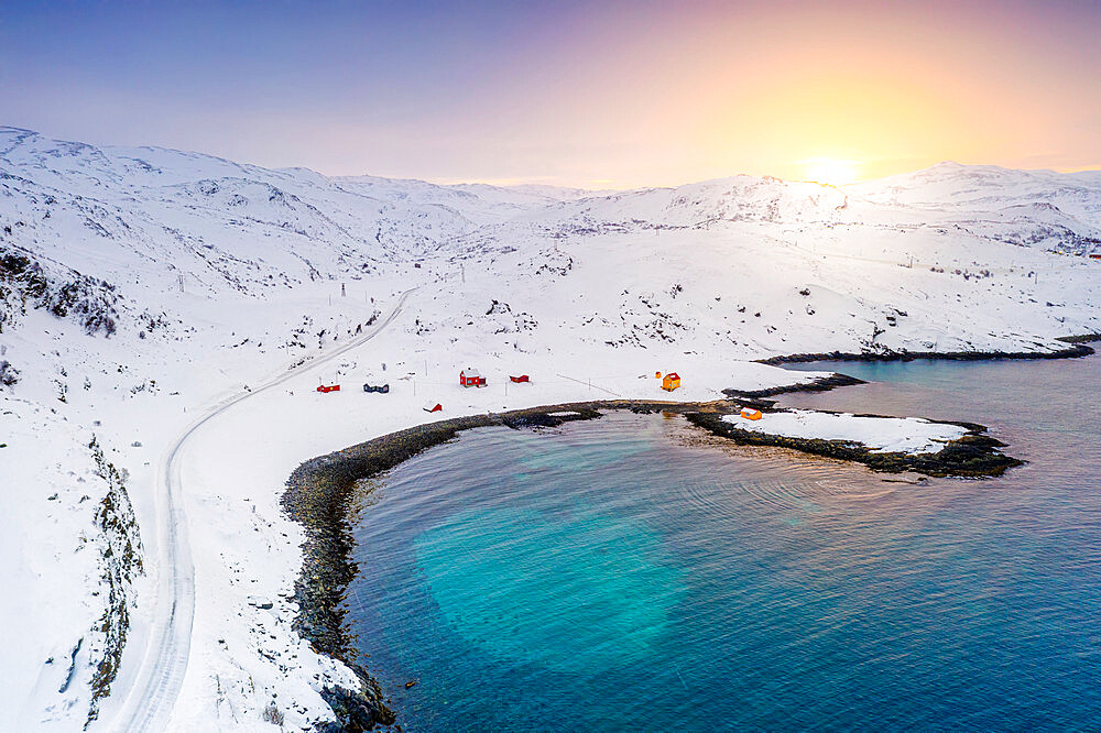 Snowy road towards the fishing village of Breivikbotn at sunset, Soroya Island, Hasvik, Troms og Finnmark, Northern Norway, Scandinavia, Europe