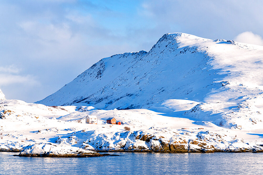 Winter sun over isolated fishermen huts in the snow, Hasvik, Soroya Island, Troms og Finnmark, Arctic, Northern Norway, Scandinavia, Europe