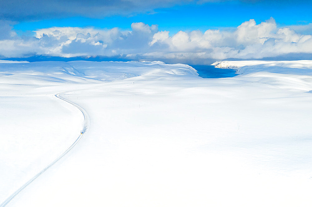 Aerial view of empty road towards Nordkapp (North Cape) crossing the landscape covered by deep snow, Troms og Finnmark, Norway, Scandinavia, Europe