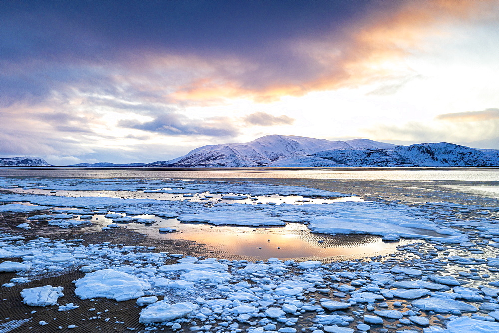 Arctic sunset on snow capped mountains and frozen sea, Tanamunningen Nature Reserve, Leirpollen, Troms og Finnmark, Arctic, Norway, Scandinavia, Europe