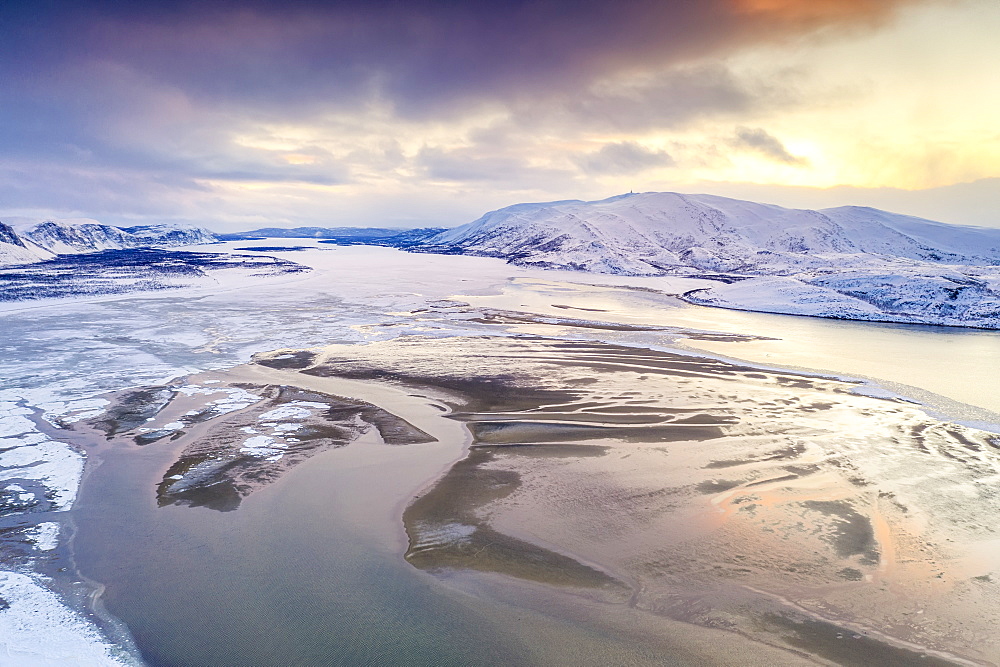 Aerial view of cold sea framed by snow capped mountains at sunset, Tanamunningen Nature Reserve, Leirpollen, Finnmark, Arctic, Norway, Scandinavia, Europe