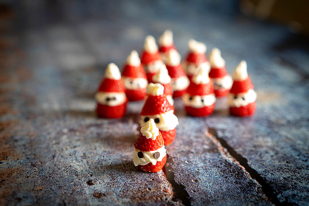 Close-up of cute strawberries shaped as Santa Claus filled with whipped cream and chocolate pieces for Christmas, Italy, Europe