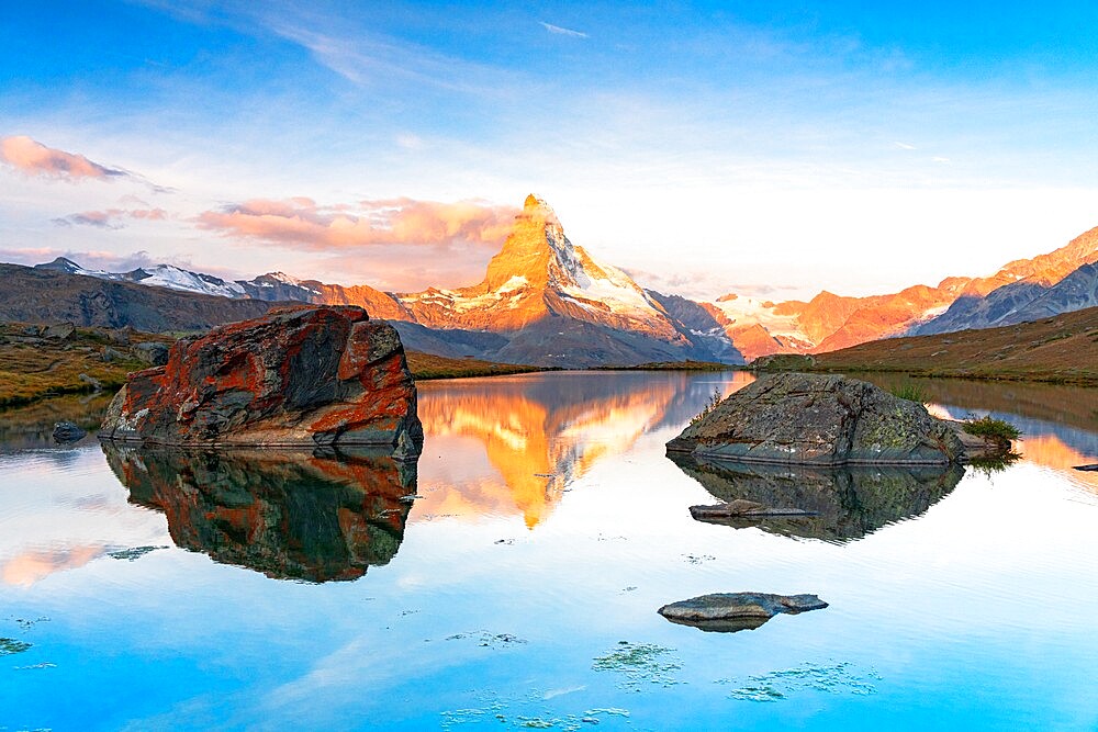 Matterhorn lit by sunrise reflected in the calm water of lake Stellisee, Zermatt, Valais Canton, Switzerland, Europe