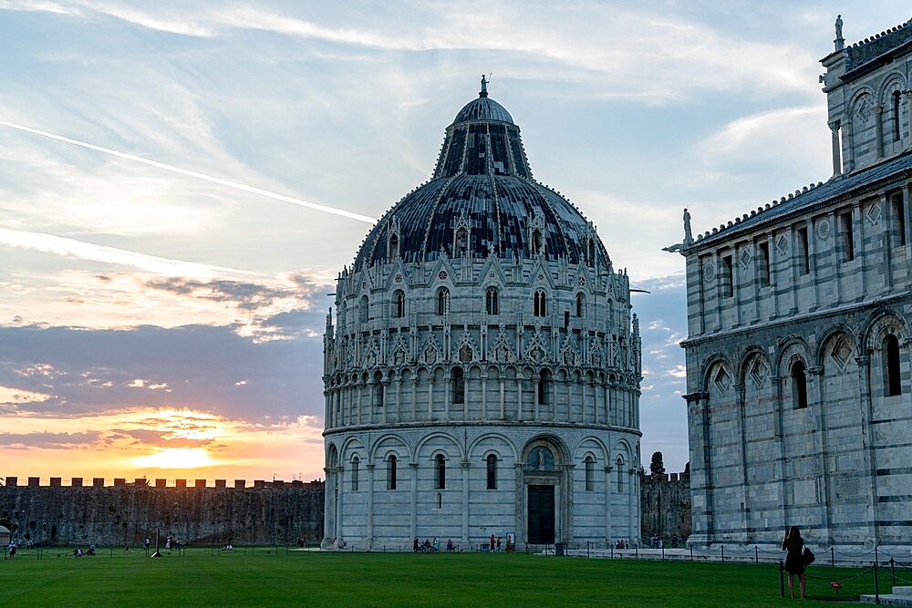 Woman admiring the majestic Pisa Cathedral (Duomo) and Baptistery at sunset, Piazza dei Miracoli, UNESCO World Heritage Site, Pisa, Tuscany, Italy, Europe