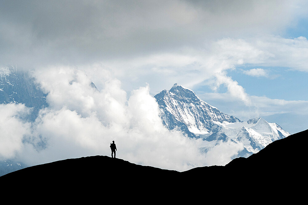 Silhouette of hiker man admiring Jungfrau mountain peak from First, Grindelwald, Bernese Alps, Canton of Bern, Switzerland, Europe