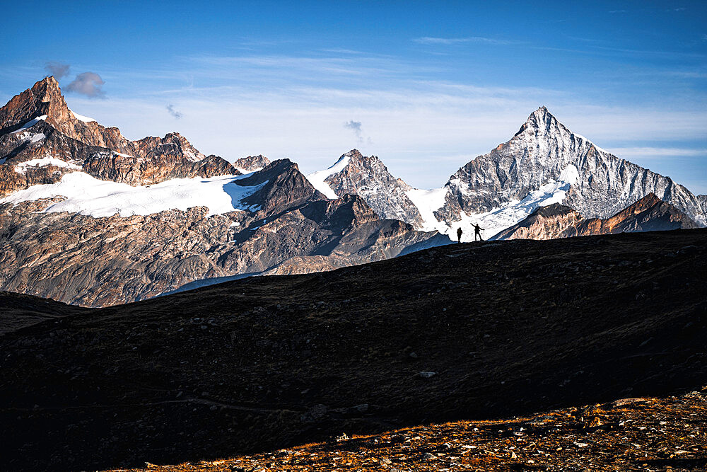 Silhouette of hikers admiring Weisshorn peak, canton of Valais, Switzerland, Europe