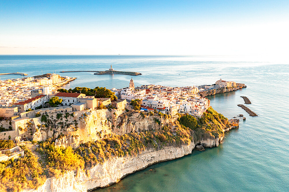 Old town of Vieste perched on cliffs at sunrise, aerial view, Foggia province, Gargano National Park, Apulia, Italy, Europe