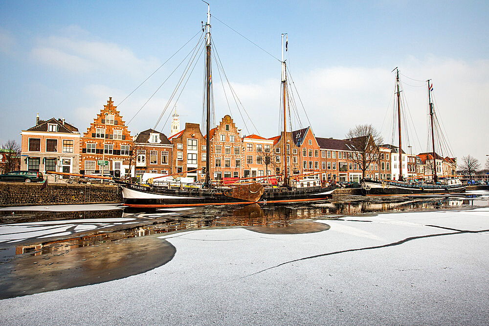 House facades and boats moored in the frozen canal of Spaarne river, Haarlem, Amsterdam district, North Holland, The Netherlands, Europe