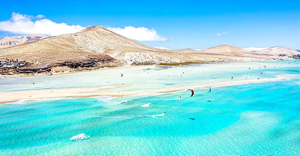 People kiteboarding on waves crashing on white sand of Sotavento beach, Jandia, Fuerteventura, Canary Islands, Spain, Atlantic, Europe