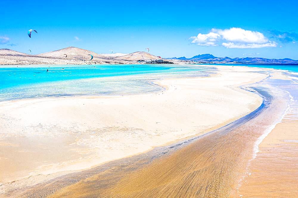 People kiteboarding on waves crashing on white sand of Sotavento beach, Fuerteventura, Canary Islands, Spain, Atlantic, Europe