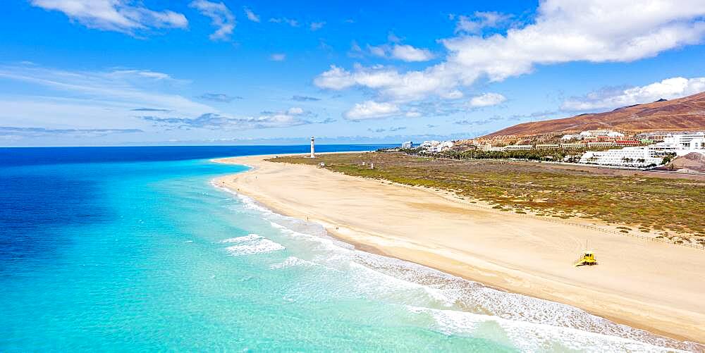 White sand beach washed by the turquoise sea with lighthouse in background, Morro Jable, Fuerteventura, Canary Islands, Spain, Atlantic, Europe