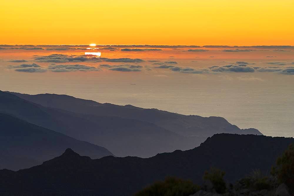 Burning sky at sunset over the Atlantic Ocean and silhouettes of mountains from Pico Ruivo peak, Madeira, Portugal, Atlantic, Europe