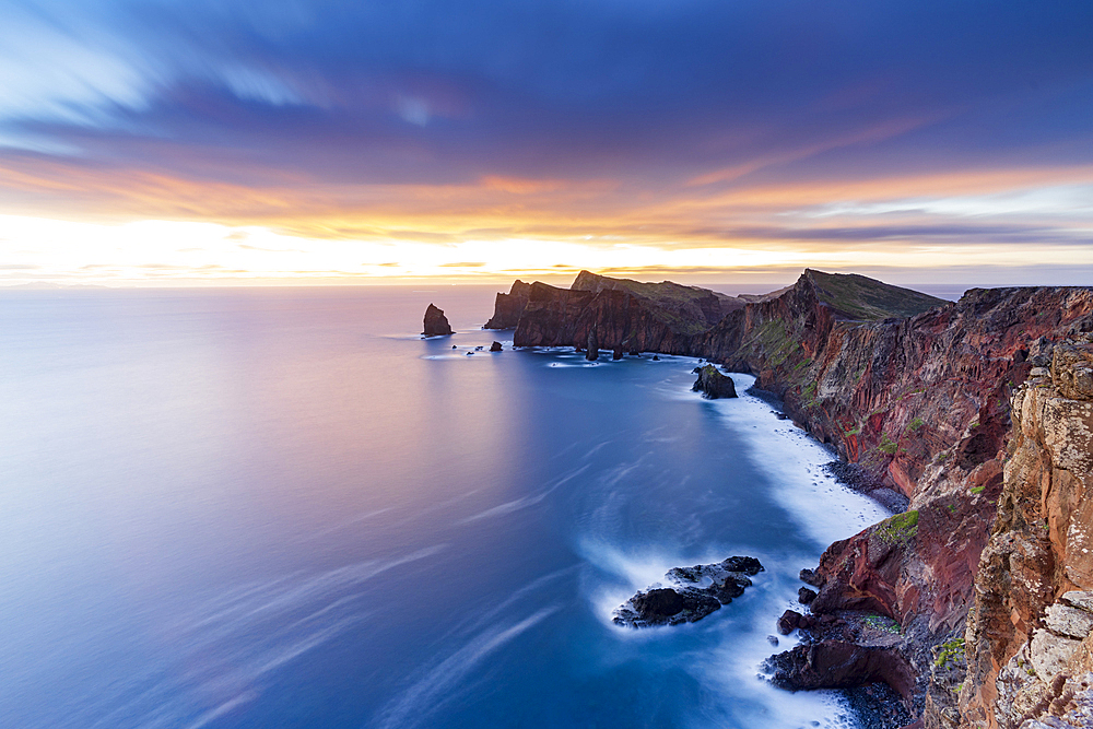 Dramatic sky at dawn on cliffs washed by ocean from Ponta Do Rosto viewpoint, Sao Lourenco Peninsula, Madeira, Portugal, Atlantic, Europe