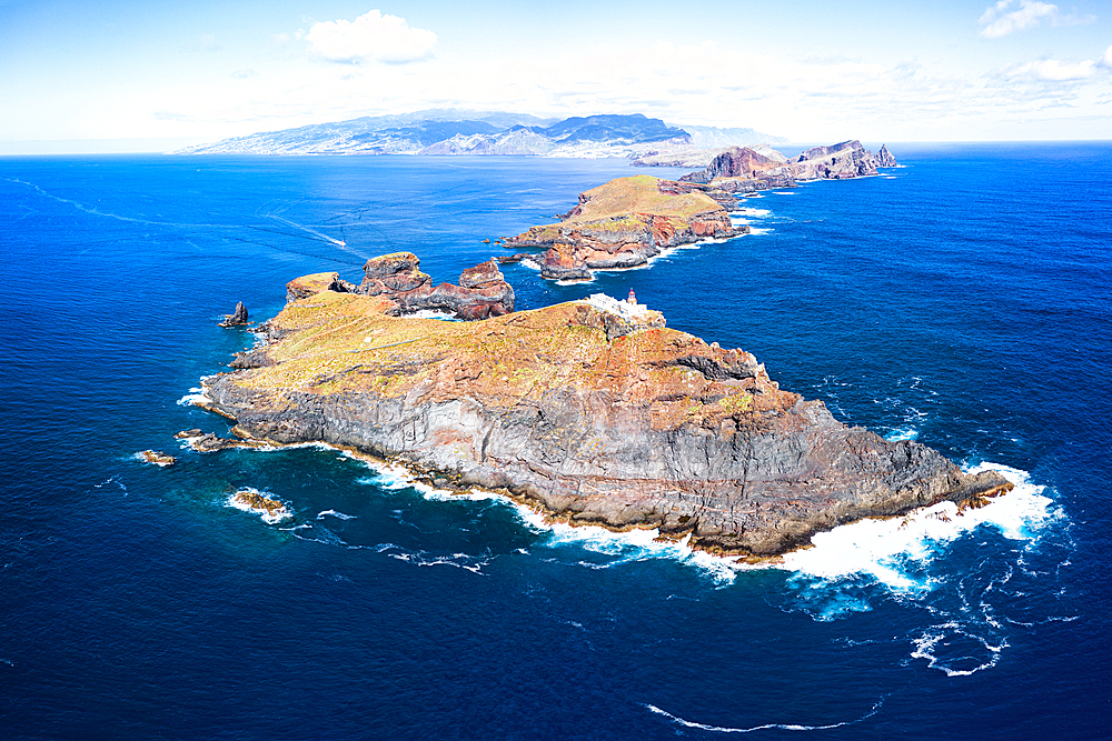 Aerial view of lighthouse on cliffs in the blue Atlantic Ocean, Sao Lourenco Peninsula, Canical, Madeira island, Portugal, Europe