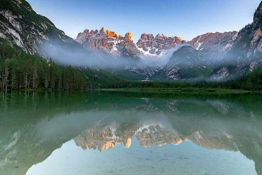 Lake Landro and woods at sunset with Cristallo and Popena group reflected in water, Dolomites, South Tyrol, Italy, Europe