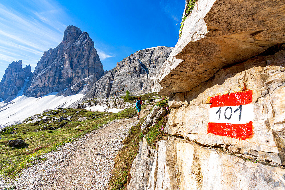 Rear view of hiker woman walking on path to majestic Croda Dei Toni mountain, Sesto Dolomites, South Tyrol, Italy, Europe