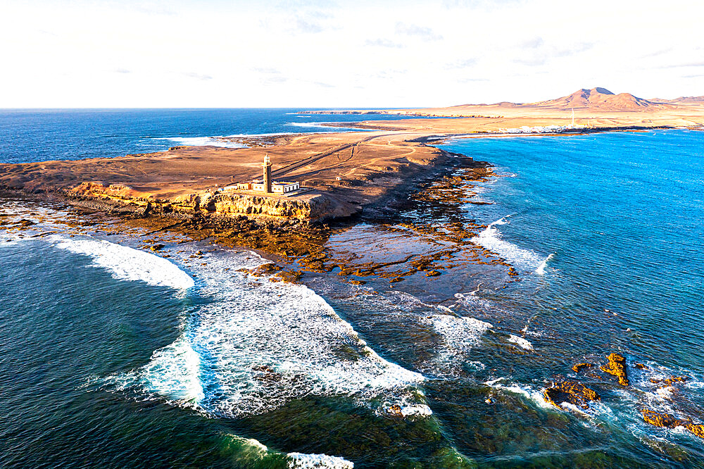 Sunset over the lighthouse of Punta Jandia (Faro de la Lola) washed by ocean waves, Fuerteventura, Canary Islands, Spain, Atlantic, Europe