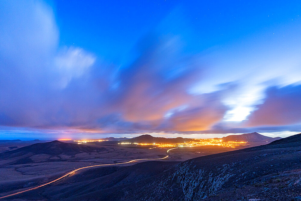 Car trail lights on desert road crossing the barren land at dusk, Vallebron lookout, Fuerteventura, Canary Islands, Spain, Atlantic, Europe