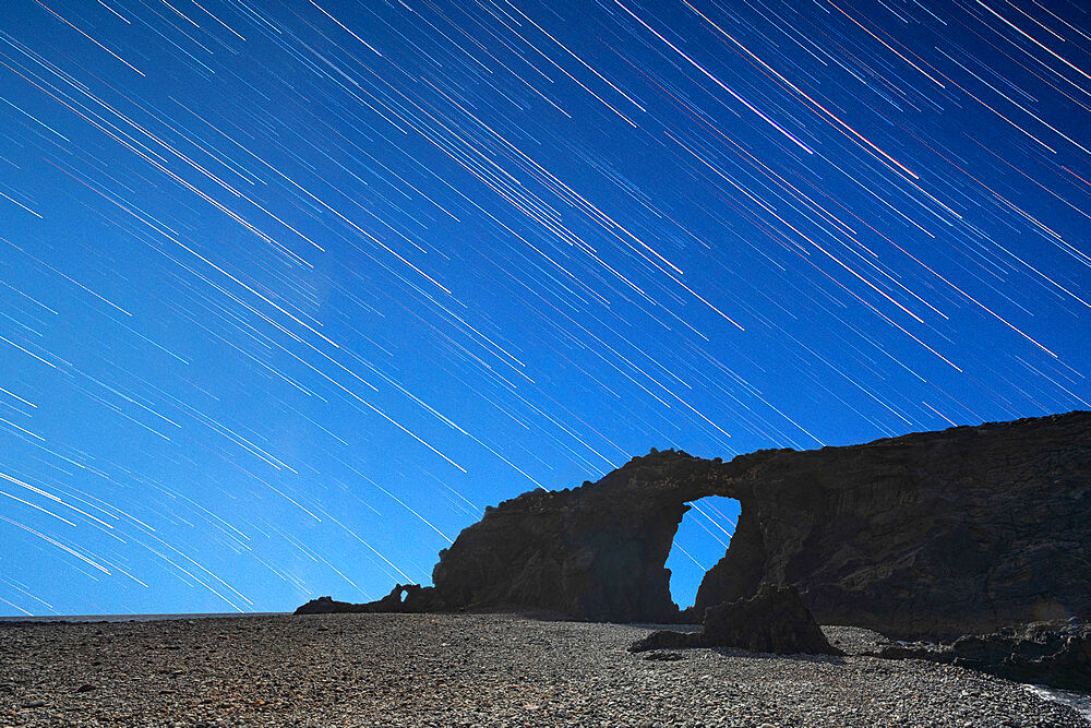 Startrail over the natural stone arch Arco del Jurado at Pena Horadada beach, Fuerteventura, Canary Islands, Spain, Atlantic, Europe