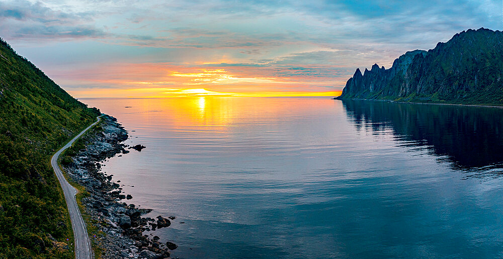 Empty asphalt road on edge of the arctic sea hit by the midnight sun, Ersfjord, Senja, Troms county, Norway, Scandinavia, Europe