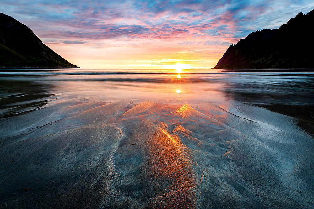 Warm lights of sunset reflecting on sand at Ersfjord beach, Senja island, Troms county, Norway, Scandinavia, Europe