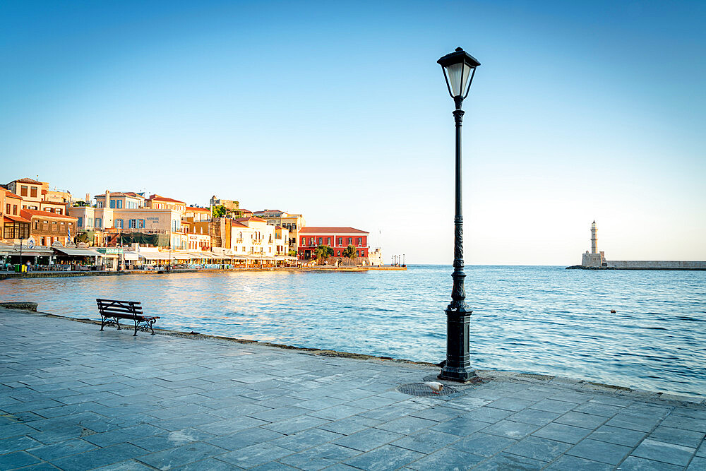 Old lantern in the Venetian harbour of Chania with lighthouse in background, Crete, Greek Islands, Greece, Europe