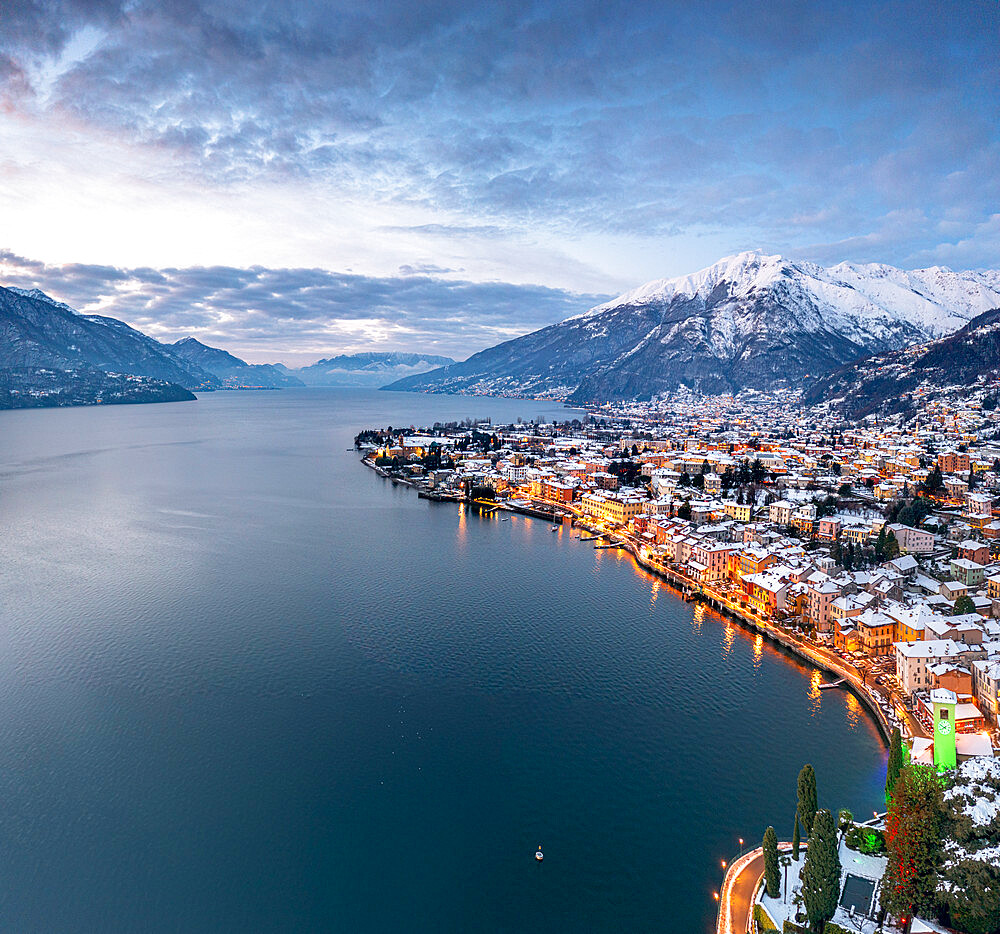 Winter sunrise over the illuminated lakeside town of Gravedona and snowy peaks, Lake Como, province of Como, Lombardy, Italian Lakes, Italy, Europe