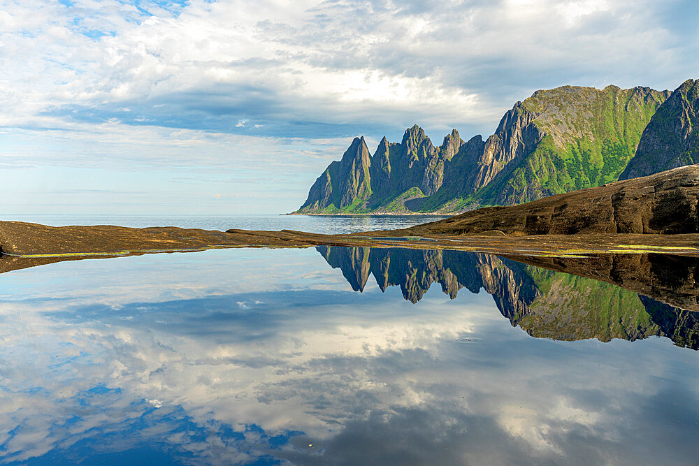 Cloudy sky over majestic rocks of mountain peaks mirrored in water, Tungeneset, Senja, Troms county, Norway, Scandinavia, Europe