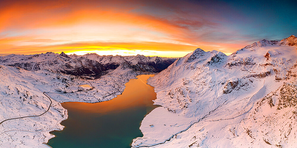 Aerial view of Lago Bianco and Bernina Pass road crossing the snowcapped mountains at dawn, Engadine, Graubunden, Switzerland, Europe