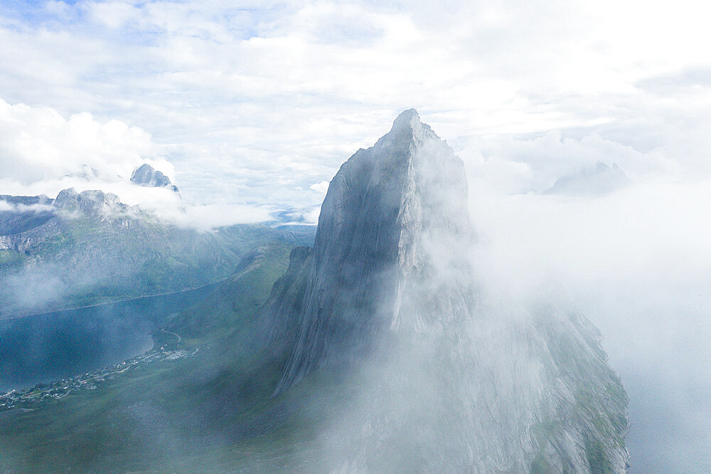 Aerial view of fog over the majestic Segla Mountain peak emerging from clouds, Senja island, Troms county, Norway, Scandinavia, Europe