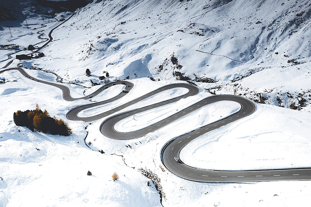 Car traveling on bends of winding road in the snow, Julier Pass, Albula district, Engadine, canton of Graubunden, Switzerland, Europe