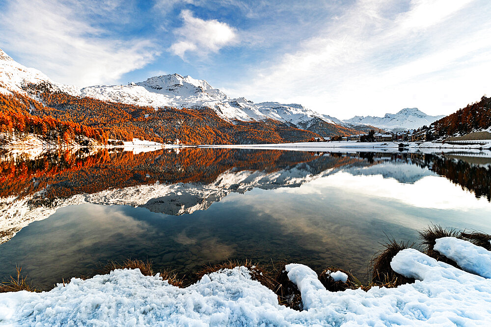 Sunset over Piz Da La Margna and Piz Corvatsch peaks reflected in lake Champfer during a snowy autumn, Engadine, Graubunden, Switzerland, Europe