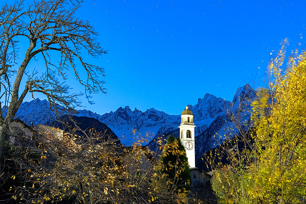 Starry night on the snowcapped Piz Badile and Cengalo peaks framed by the bell tower, Soglio, Graubunden Canton, Switzerland, Europe