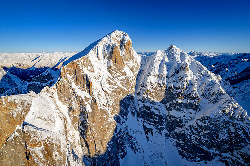 Clear sky over majestic Pizzo Cengalo in winter, aerial view, Val Masino, Valtellina, Sondrio province, Lombardy, Italy, Europe