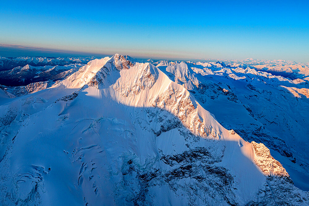 Aerial view of the snow covered Piz Bernina and Biancograt mountains at dawn, Engadine, Graubunden Canton, Swiss Alps, Switzerland, Europe