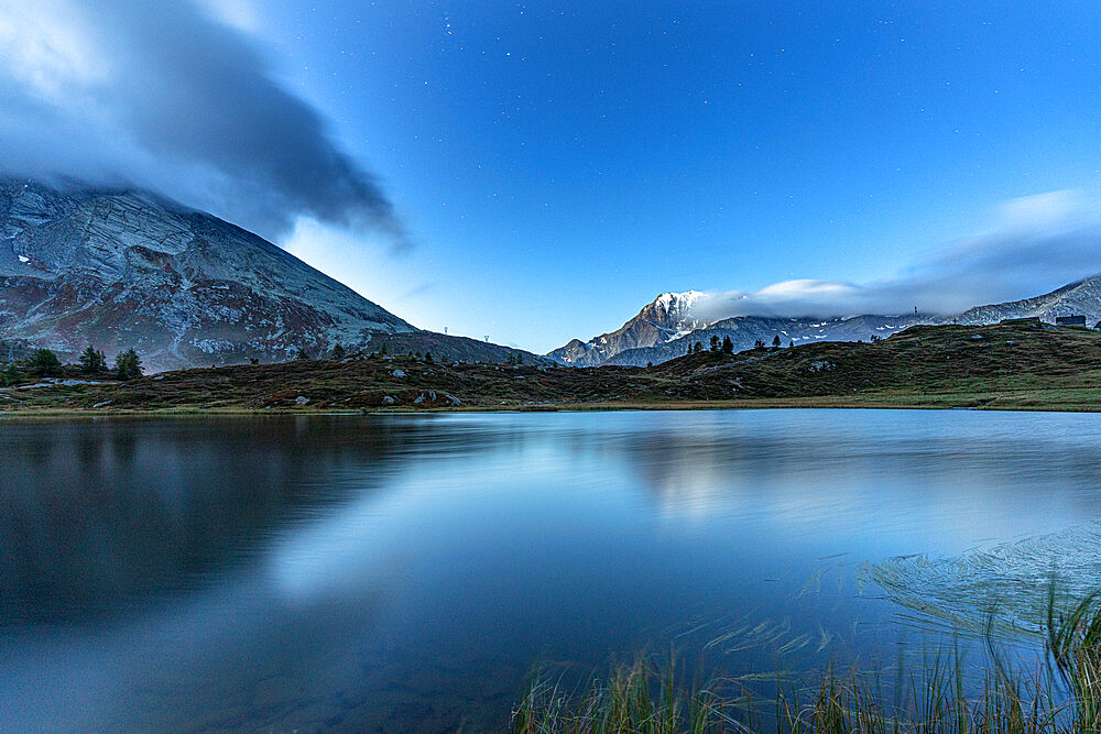 Fletschhorn mountain peak reflected in the pristine water of Hopschusee lake at dusk, Simplon Pass, Valais Canton, Swiss Alps, Switzerland, Europe