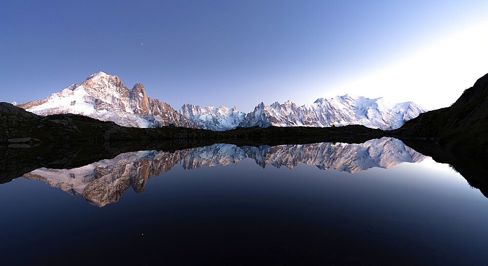 Snowy peaks of Mont Blanc massif mirrored in the clear water of Lacs de Cheserys at dusk, Chamonix, Haute Savoie, French Alps, France, Europe